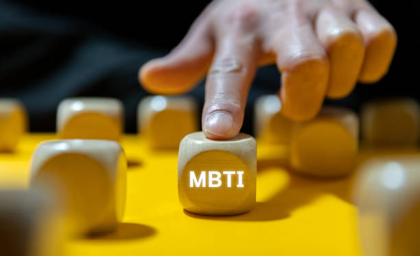 나무 큐브에 쓰인 MBTI 글자를 손가락으로 선택하는 장면
